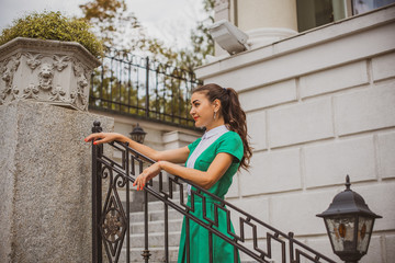 Retro lifestyle fashion portrait of young stylish arabic woman walking on the street, wearing trendy vintage, travel on a old Europe at autumn time 