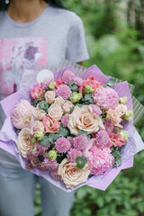 Beautiful summer bouquet. Arrangement with mix flowers. Young girl holding a flower bunch with peony. The concept of a flower shop. Content for the catalog