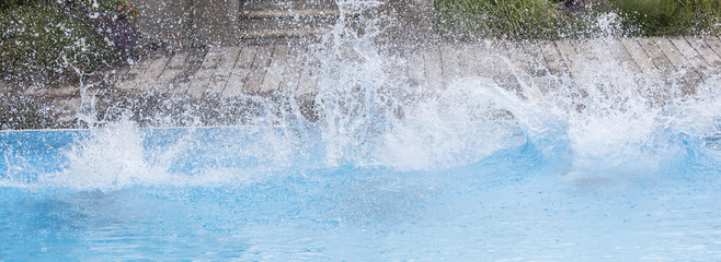 Splashing water on the surface of the pool after the impact of jumping people.