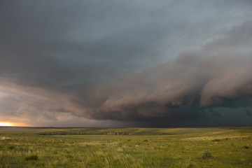 A severe thunderstorm approaches over the great plains landscape. The early evening sun casts an...