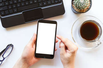 white office table with office supplies and mobile phone with blank white screen