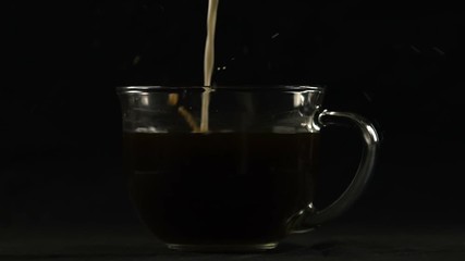 Milk poured into coffee, hot drink with caffeine for night work, close up