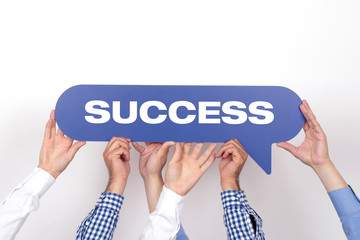 Group of people holding the SUCCESS written speech bubble