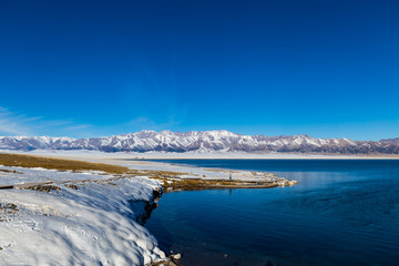   The frozen Sailimu lake with snow mountain background at Yili, Xinjiang of China