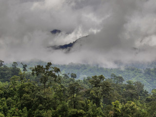 Wild monsoon clouds cover forested mountainous slopes in Kanchanaburi Province, eastern Thailand