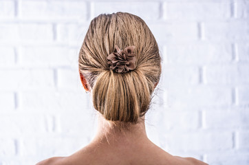 Head of a young woman from behind. Rear view braid hairdo. Hair bun