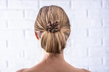 Crédence de cuisine en verre imprimé Salon de coiffure Head of a young woman from behind. Rear view braid hairdo. Hair bun