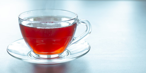 A glass mug with hot black tea