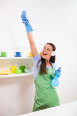 Young happy woman is cleaning the kitchen. 