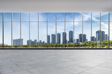 Fototapeta premium Panoramiczna linia horyzontu i nowożytni biznesowi budynki biurowi z pustą drogą, pusta betonowa podłoga