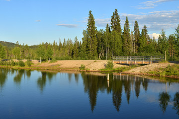 Summer landscape. Picturesque lake with trees reflection in Finnish Lapland