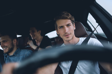 A group of people inside a car, on a road trip