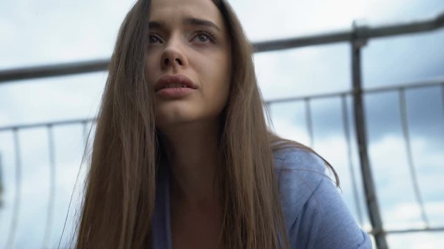 Woman crying, sitting on street, breakup loss of close person, mental disorder