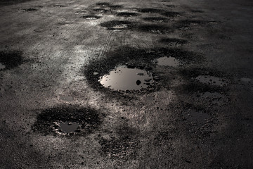 pothole in the road looking like alien craters