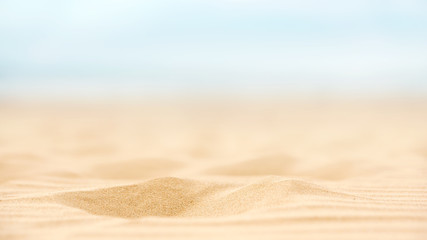 Close up sand beach with blurred sea sky background, summer day, copy space. - obrazy, fototapety, plakaty