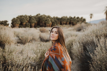 Smiling beautiful hipster traveler girl in gypsy look in desert nature.  Artistic photo of young...