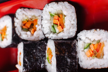 Fresh food portion in japanese bento box with salad, main course. Sushi roll with vegetables. Vegetarian dish.