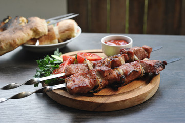 pork kebab on skewers with vegetables and herbs