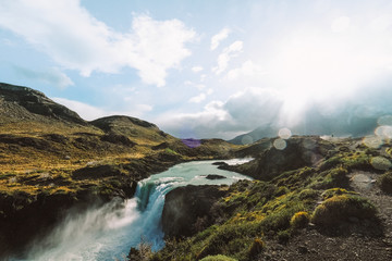 Waterfall landscapes with green hills and turquoise water. Chile. Torres del Paine