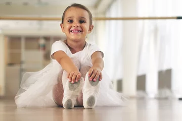 Türaufkleber Tanzschule Porträt eines schönen, sehr jungen Mädchens, das in einer Tanzschule ein weißes Tutu trägt und alleine trainiert, um neue Tanzschritte zu lernen. Konzept von: Ehrgeiz, Bildung, Eleganz und Liebe zum Tanz...