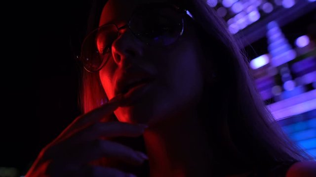 Drunk seductive woman in night club posing for camera, flirting at disco