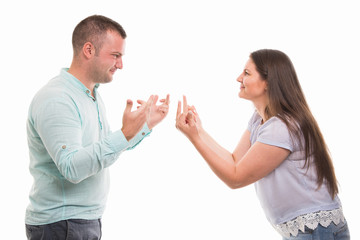 Side view of young couple showing each other middle finger