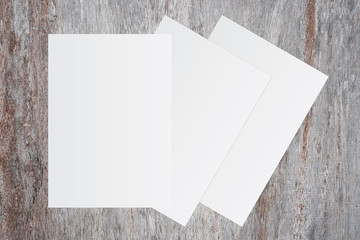 Blank white paper on brown wooden background for text input.