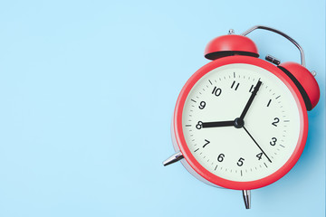 Red vintage alarm Clock show 8 O'Clock with copy space on light blue background