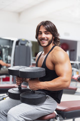 Fototapeta na wymiar Bodybuilder lifting dumbbell weights in a gym