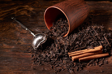 dry black chinese tea set,with strainer closeup,cups and teapot on background over old wood board