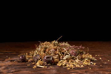 Herbal tea on wooden table on black background. Concept organic food