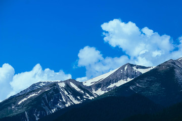 Beautiful alpine ice mountains peaks with snow, summer time, blue sky background.