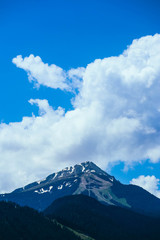 Beautiful alpine ice mountains peaks with snow, summer time, blue sky background.