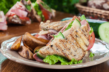 Sandwiches with ham, cheese, tomatoes, lettuce and cucumber