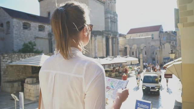 Female tourist with map visiting the city of Split.