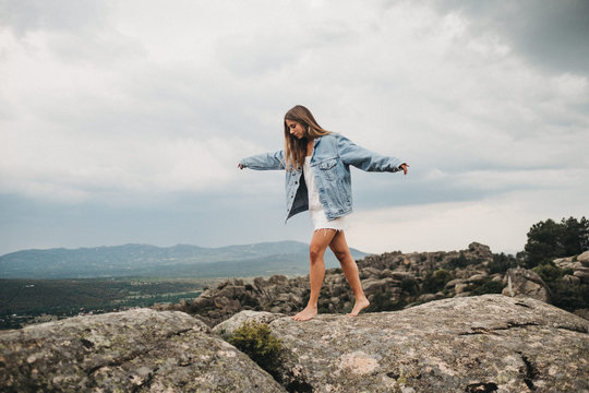 Woman jumping over crack on stones