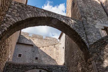 Fototapeta na wymiar Low angle view of stone castle arches and walls from an inside courtyard.