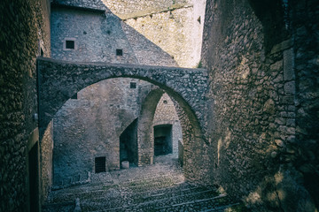 Arches and stairs of an ancient stone wall castle.