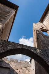 Vertical low angle view of arches of a medieval castle with blue sky background.