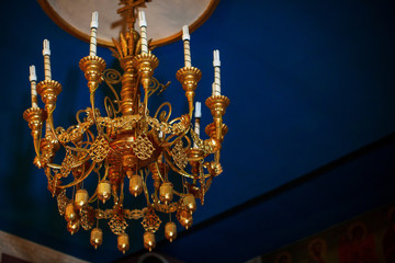 Luxurious golden chandelier with electric bulbs in church