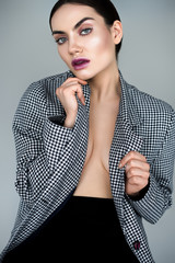 elegant seductive half naked woman posing in vintage jacket, isolated on grey