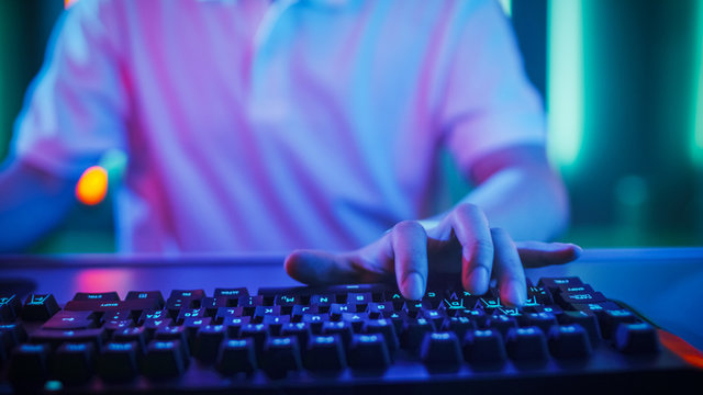 Close-up on the Hands of the Gamer Playing in the Online Video Game. Stylish Arcade Neon Bright Red, Pink, Violet, Green Colors.