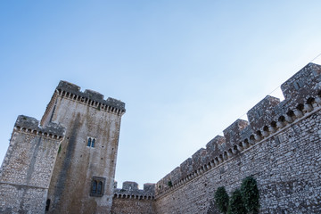 Walls and tower of ancient castle with clouds and blue sky background.