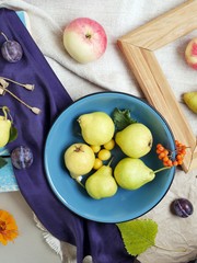 Bright colorful fruits, flowers and leaves on the surface of different textures, seasonal decorative composition, autumn, top view