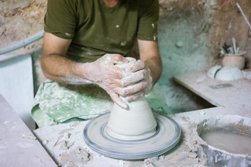 Ceramic dishes in working process. Creating ceramic pieces. Tradicional ceramic factory in spain. man working with traditional potter's wheel