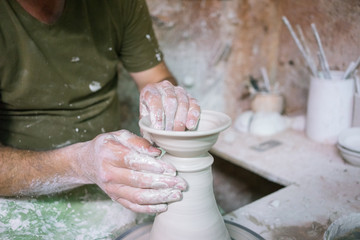 Ceramic dishes in working process. Creating ceramic pieces. Tradicional ceramic factory in spain. man working with traditional potter's wheel
