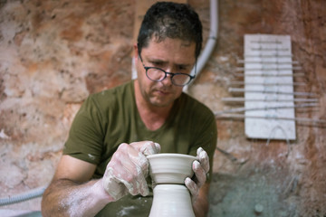 Ceramic dishes in working process. Creating ceramic pieces. Tradicional ceramic factory in spain. man working with traditional potter's wheel