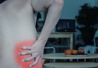 Fototapeta premium Asian man back pain and sit on bed in bedroom in the morning.color tone