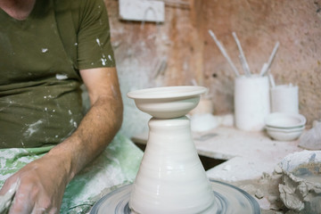 Ceramic dishes in working process. Creating ceramic pieces. Tradicional ceramic factory in spain. man working with traditional potter's wheel