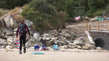 A girl bring a bodyboard back from the sea